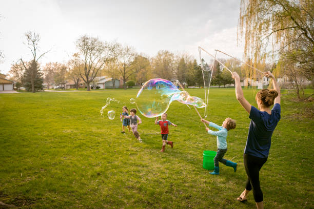 Enfants qui jouent à faire des bulles dans le jardin