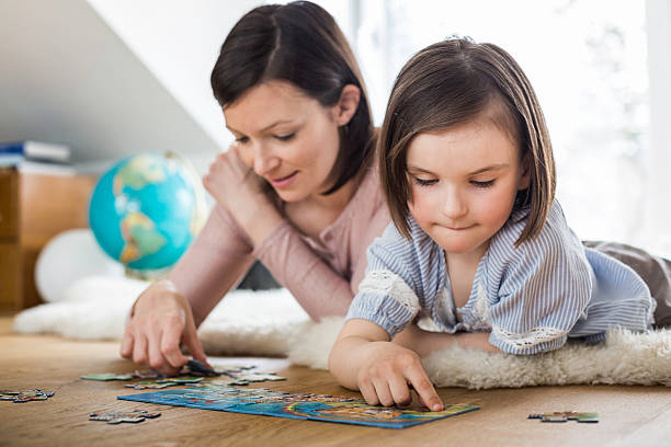 Petite fille qui fait un puzzle avec sa maman