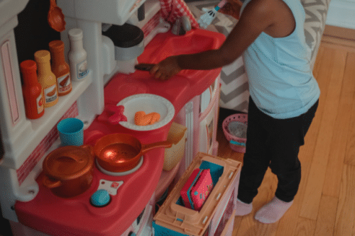 Petite fille qui joue avec une cuisine jouet